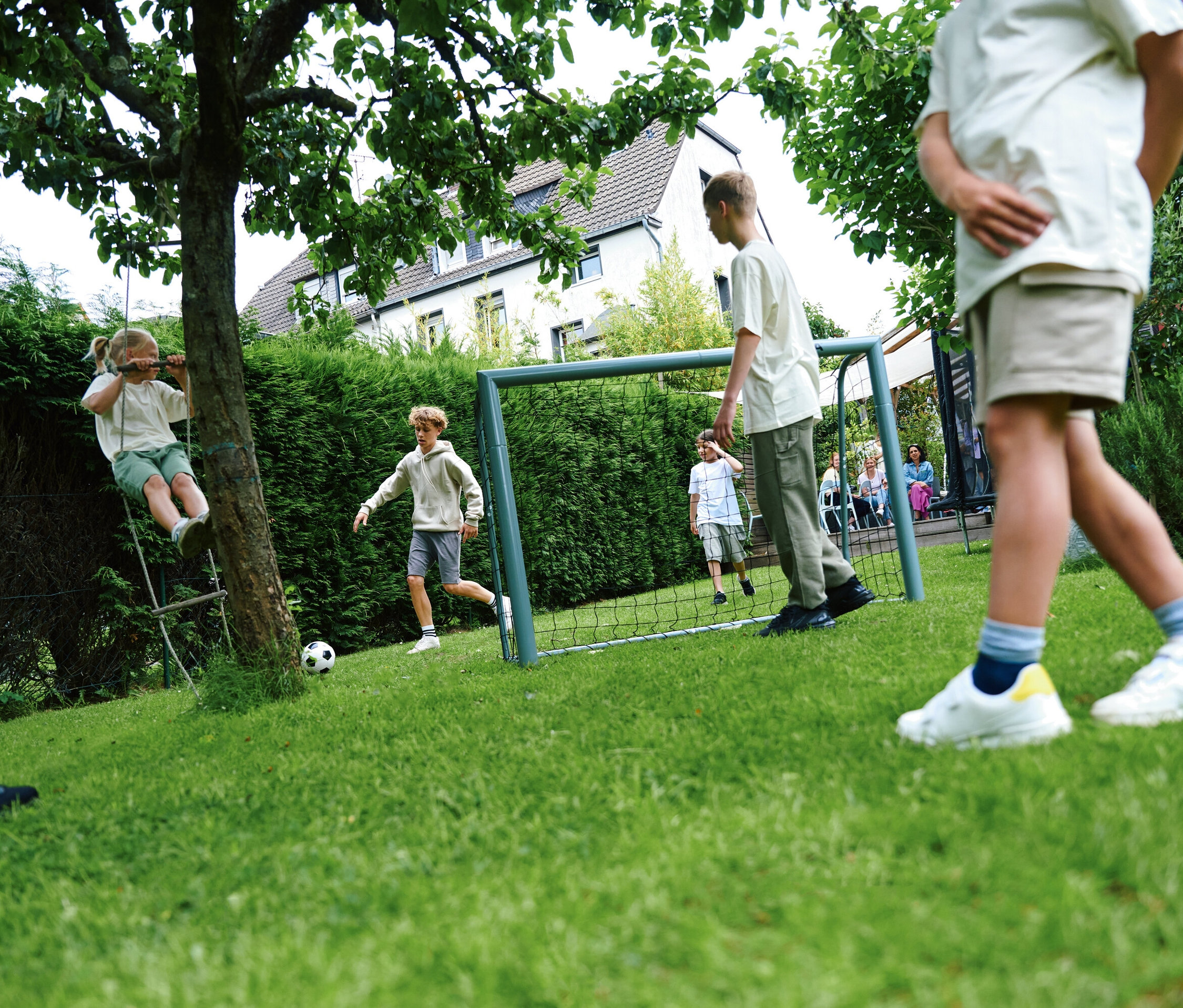 Gruppe Kinder spielt Fußball mit HUDORA Fußballtor »Expert 300« im Garten.