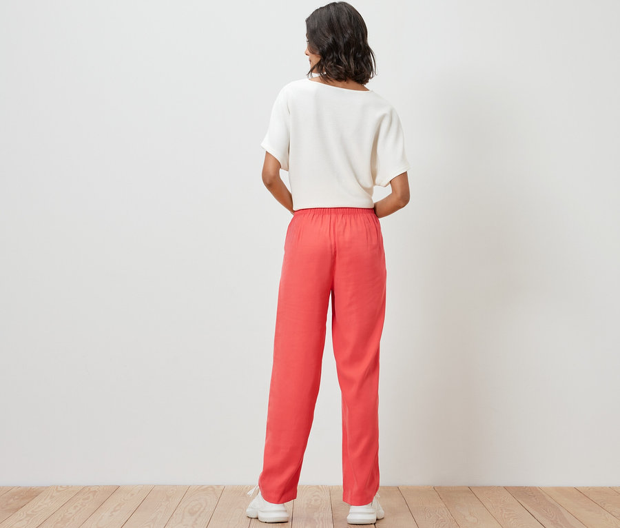 Frau trägt eine Webhose und ein Oberteil.