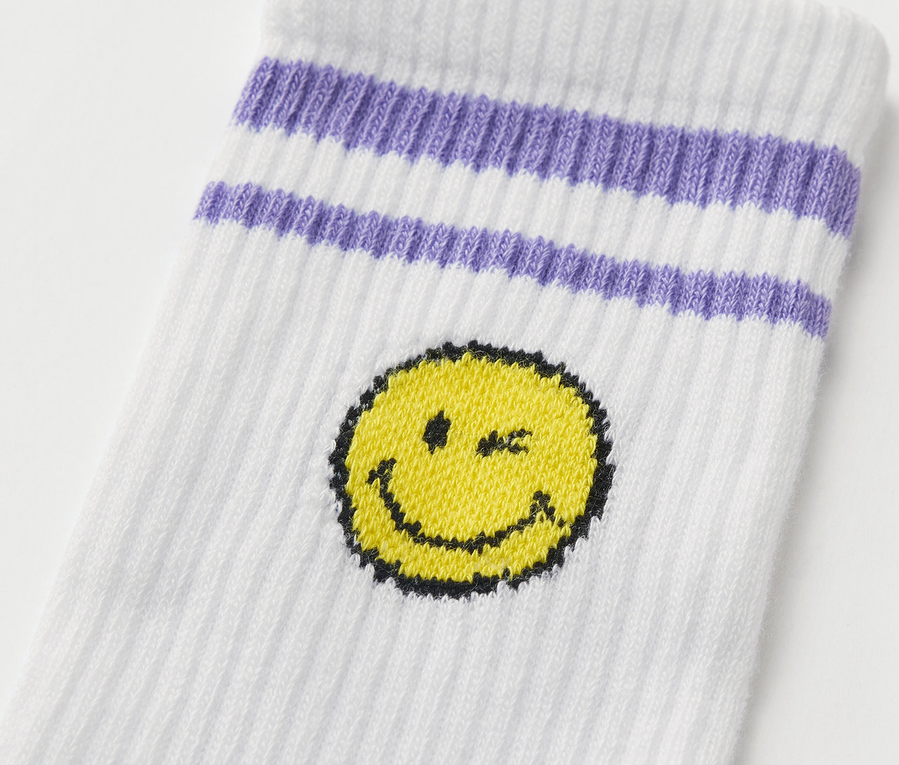Detail einer weißen Kinder-Tennissocke mit lila Streifen und gelbem Smiley von 5 Paar Kinder-Tennissocken SMILEYWORLD®.