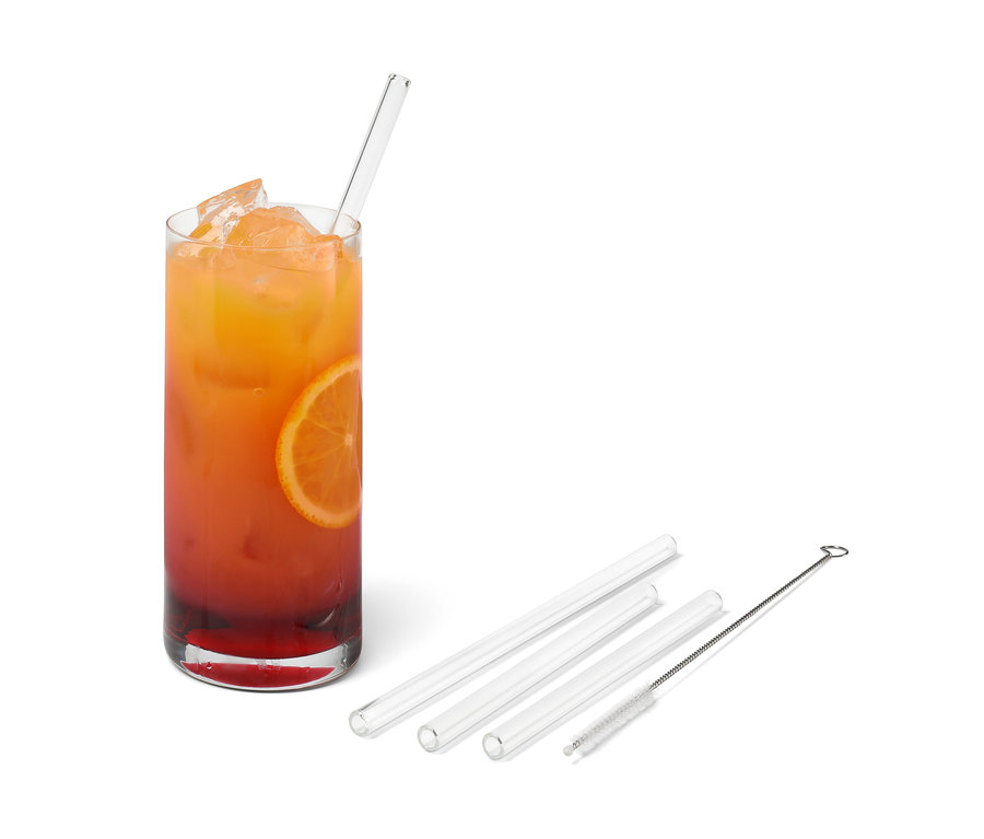 Ein Glas mit Getränk, Eis, Orangenscheibe und einem 4 Glas-Trinkhalm. Drei weitere Glas-Trinkhalme und eine Reinigungsbürste daneben.