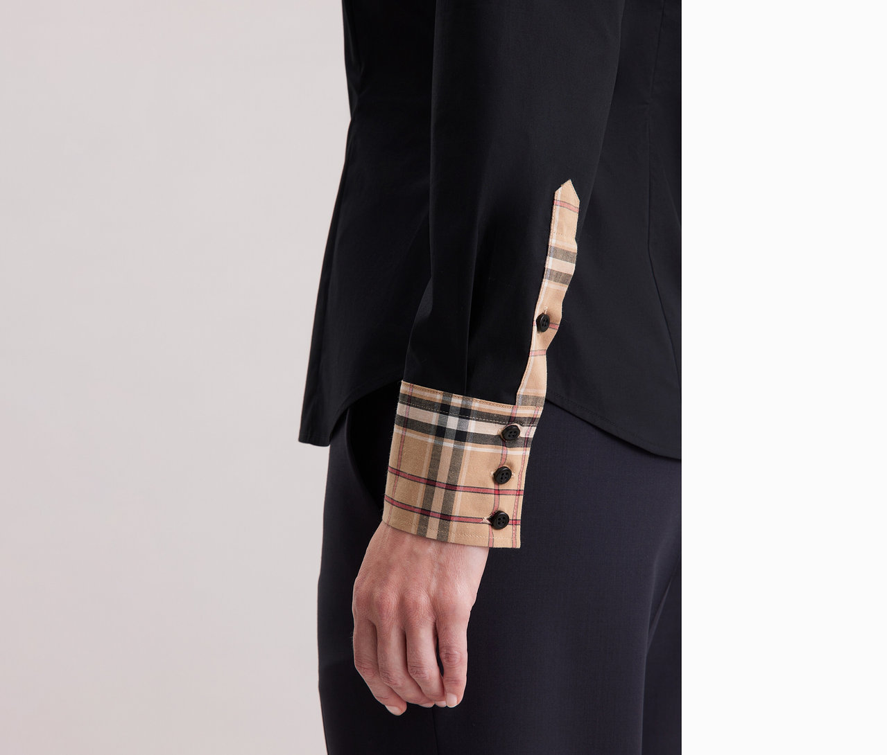 Nahaufnahme einer Frau, die eine Seidensticker Popeline-Bluse mit Karodetail trägt.