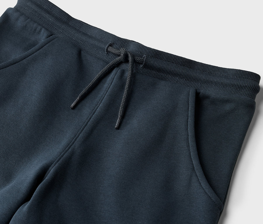 Detailaufnahme einer Kinder-Jogginghose mit Kordelzug und Tasche.