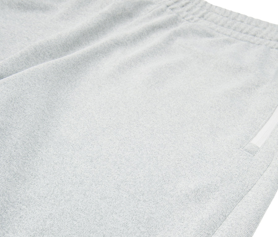 Nahaufnahme von hellgrauen Fila-Shorts mit Schlitz am Saum.
