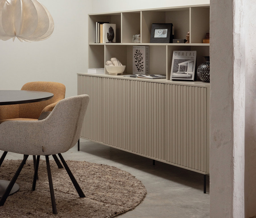 Ein Woood »New Gravure« Wandschrank steht im Raum, daneben ein Tisch und zwei Stühle.