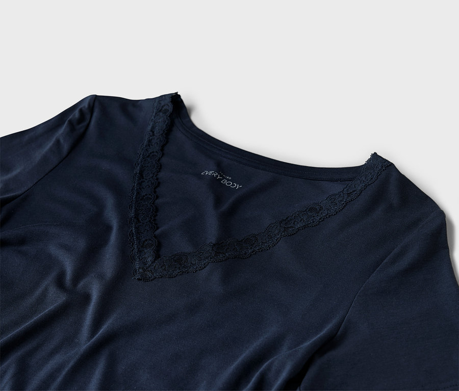 Nahaufnahme eines marineblauen V-Ausschnitt-Shirts mit Spitzendetails.