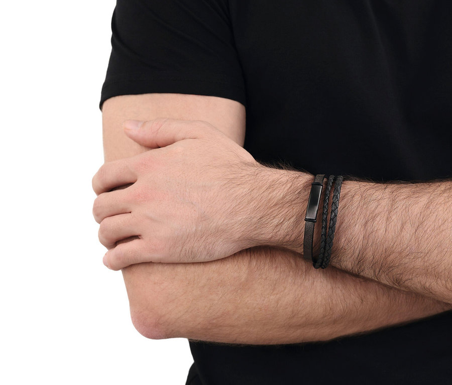 Nahaufnahme des Arms einer Person, die drei schwarze Armbänder trägt.