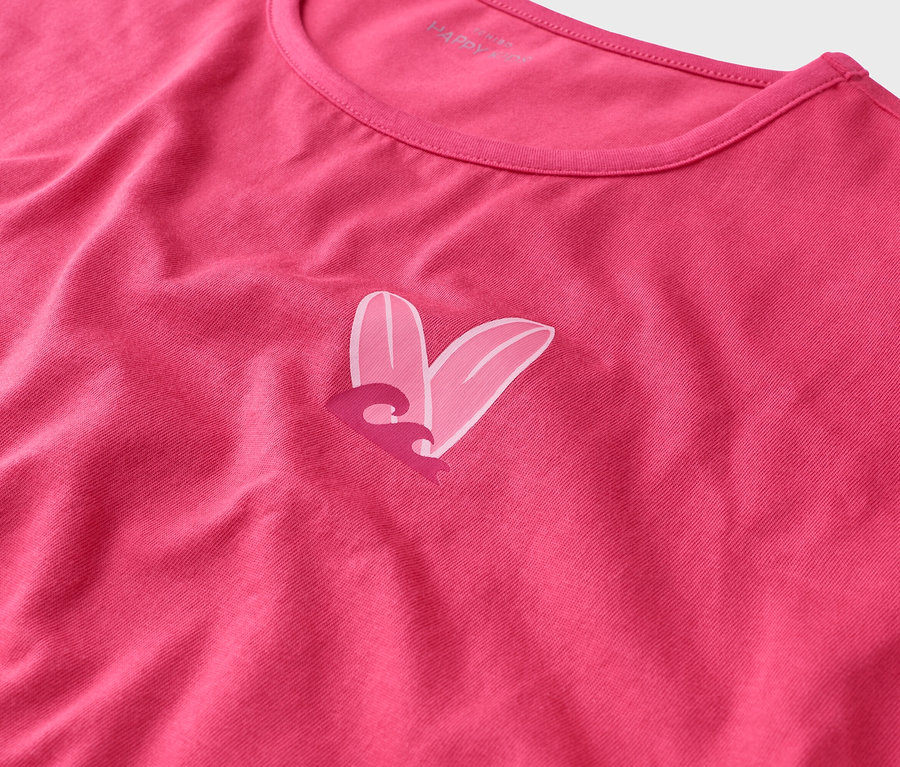Nahaufnahme eines pinken T-Shirts mit einem Herzdesign aus zwei Surfbrettern und einer Welle.