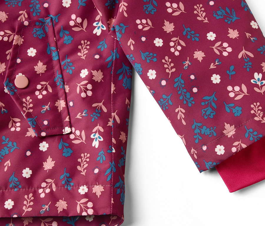 Nahaufnahme einer burgunderroten Jacke mit Blumenmuster, einer Tasche und einem roten Ärmel.