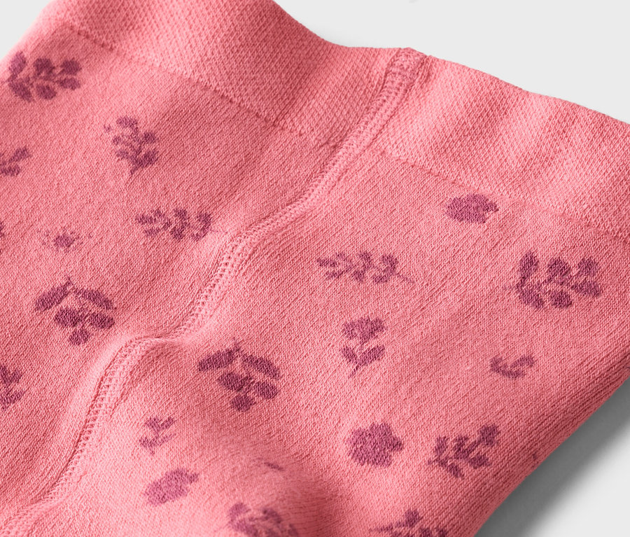 Nahaufnahme einer rosafarbenen Strumpfhose mit dunkelrosa Blumenmuster.