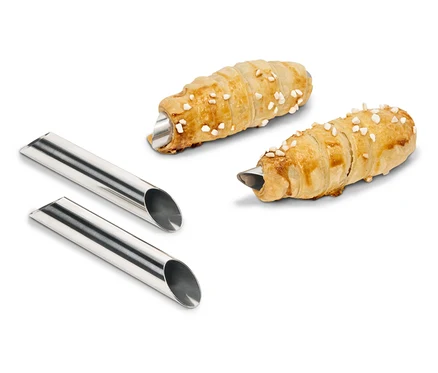 Zwei mit Creme gefüllte Teigrollen liegen neben zwei Metallformen.