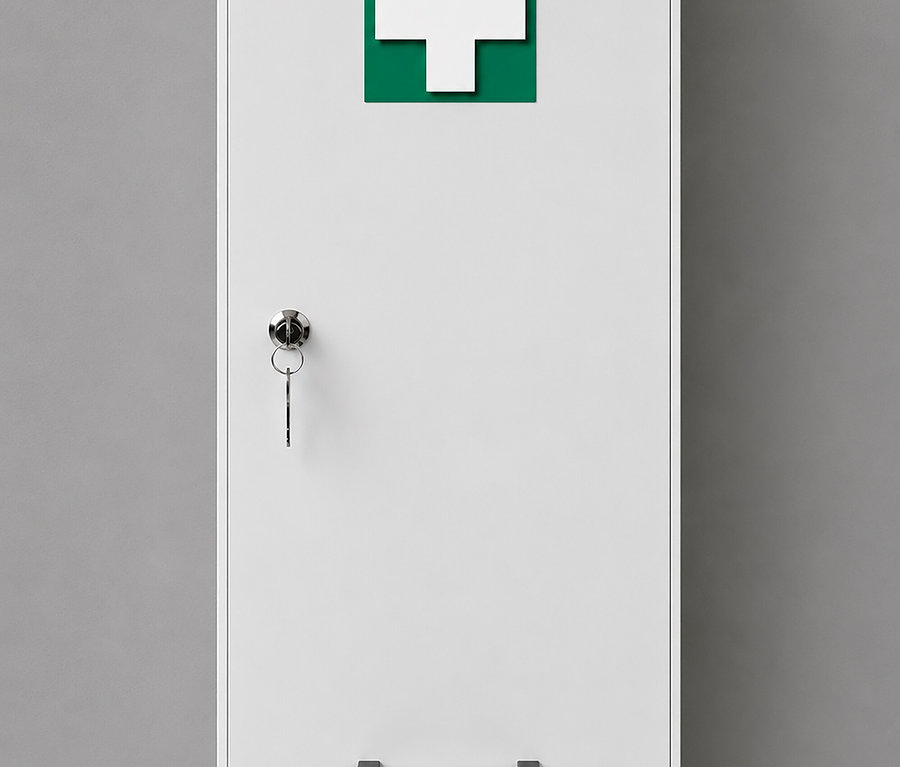 Weißer Erste-Hilfe-Schrank an einer grauen Wand, mit einem grünen Quadrat und weißem Kreuzsymbol auf der Tür. Ein silbernes Schloss mit zwei Schlüsseln hängt an der Tür, und ein schwarzer Griff befindet sich unten.
