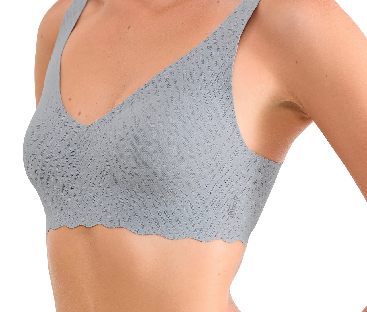 Frau trägt einen hellgrauen sloggi Zero Feel Bliss Soft Bra mit dezentem Strukturmuster und gewelltem Saum.