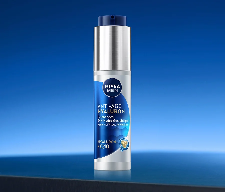 Silberne NIVEA MEN Anti-Age Hyaluron 24H Hydro Gesichtsgel Flasche mit blauem Etikett und Pumpverschluss, auf einer dunklen Oberfläche vor blauem Hintergrund.