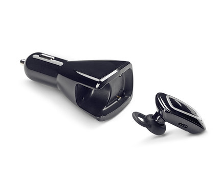 Ein schwarzes In-Ear-Freisprechanlagen-Set mit Kfz-Ladestation liegt auf einem weißen Hintergrund.