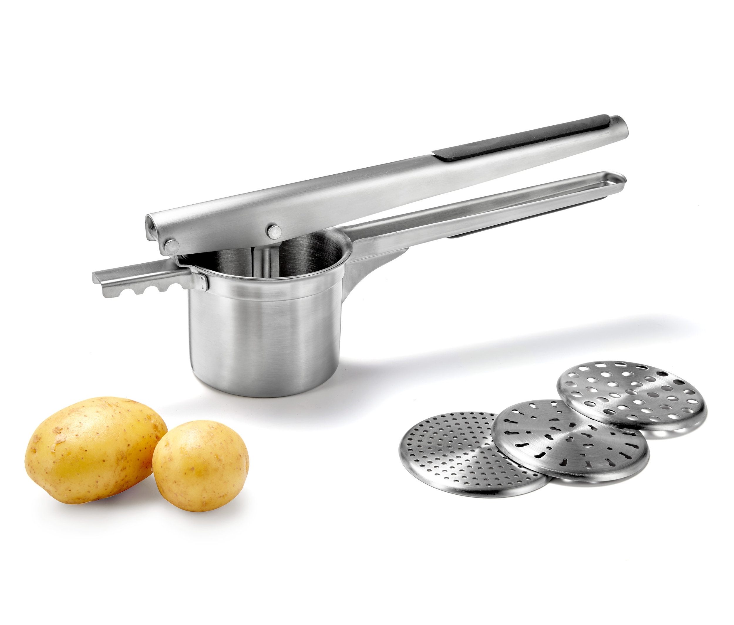 Eine Kartoffel- und Spätzlepresse aus Edelstahl mit zwei Kartoffeln und drei Scheiben auf weißem Hintergrund.