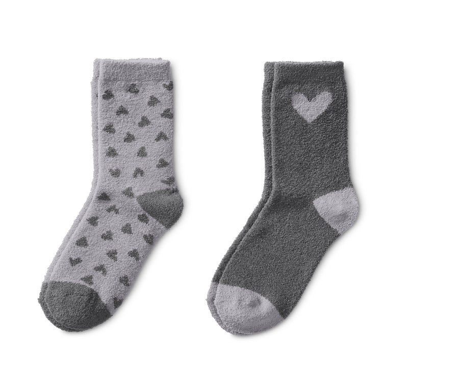 Zwei Paar Kuschelsocken: ein Paar hellgrau mit dunkelgrauen Herzen, ein Paar dunkelgrau mit hellgrauem Herz.