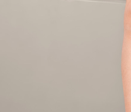 Mädchen sitzt und zeigt mit dem Finger, trägt 5 Baumwoll-Langarmbodys.