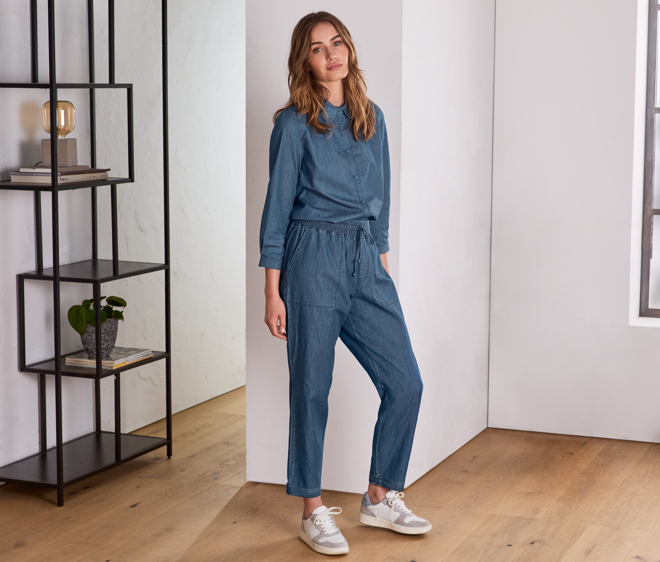 Frau posiert in Denimoptik Hose.
