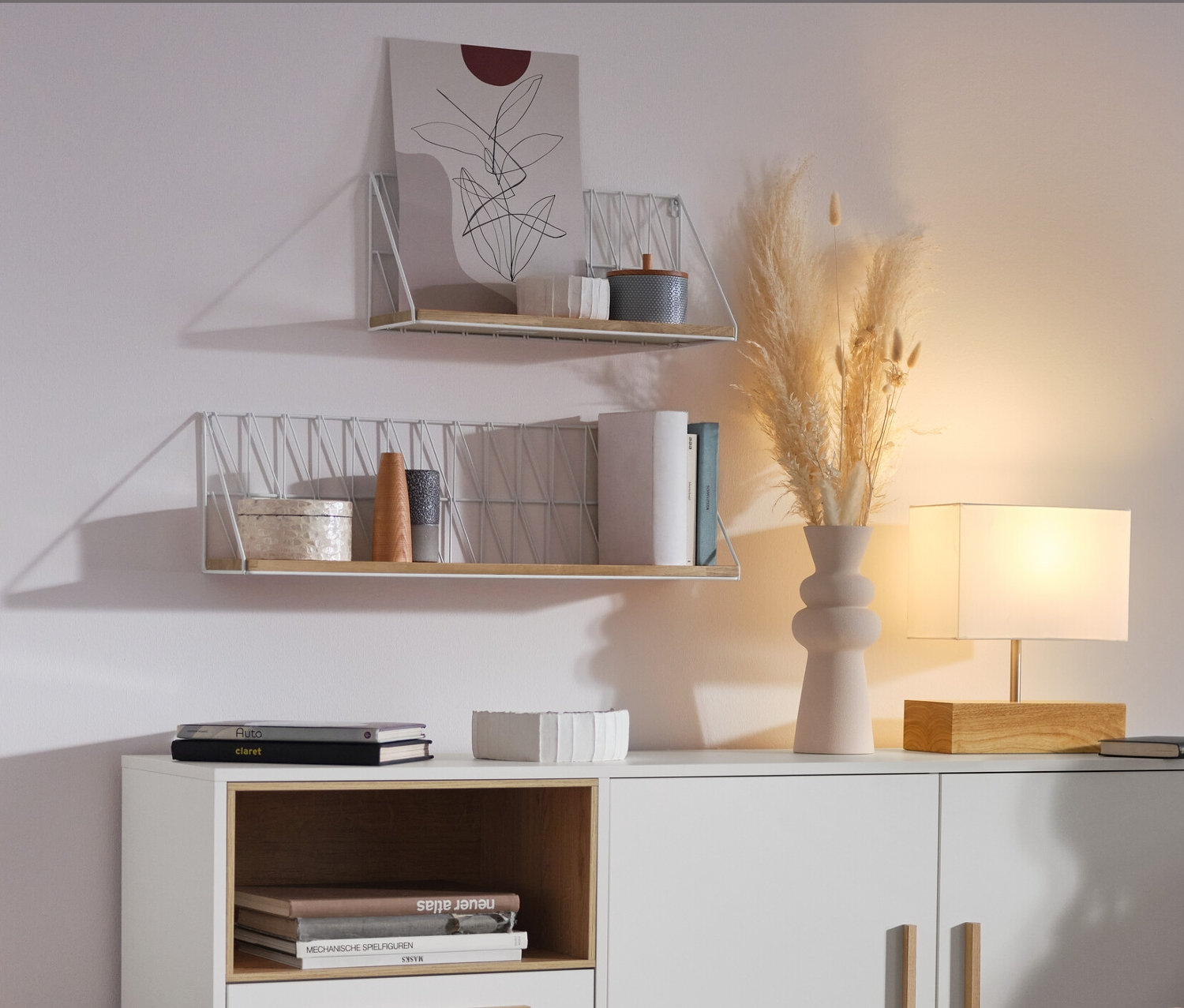 Frau sitzt im Wohnzimmer neben einem weißen Sideboard »Eklund« mit Schubladen und Tür.