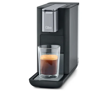 Qbo ESSENTIAL Dark Stone Kaffeemaschine mit Tasse Kaffee.