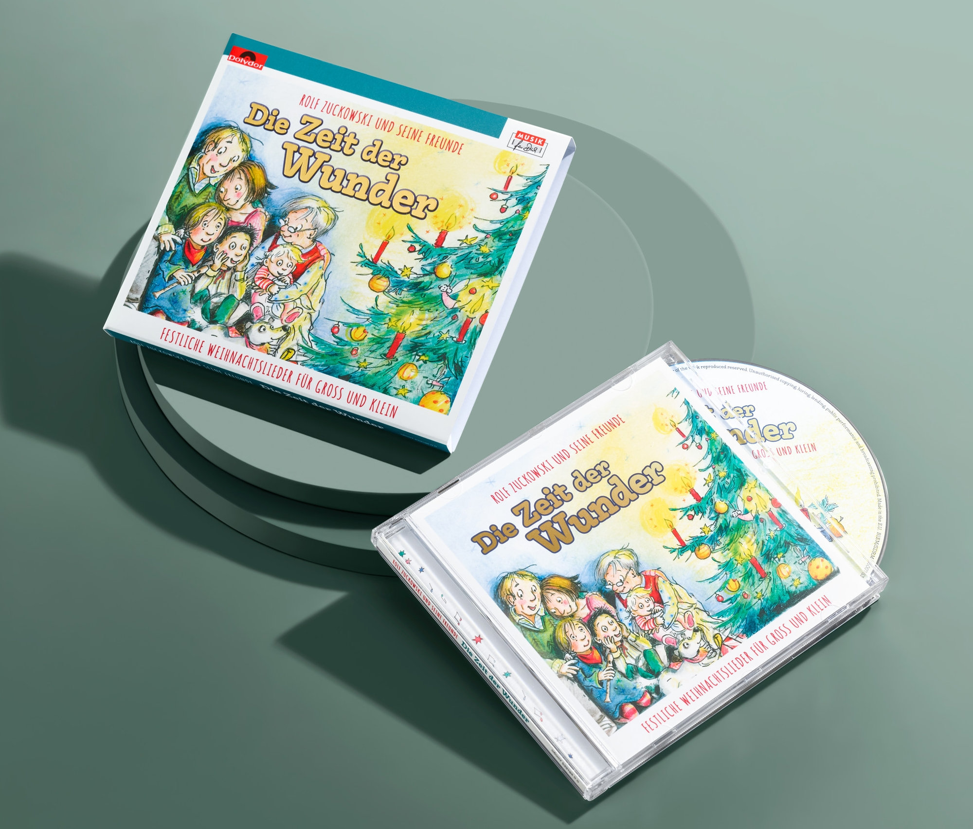 Zwei CDs »Die Zeit der Wunder – Rolf Zuckowski und seine Freunde« liegen auf grünem Untergrund.