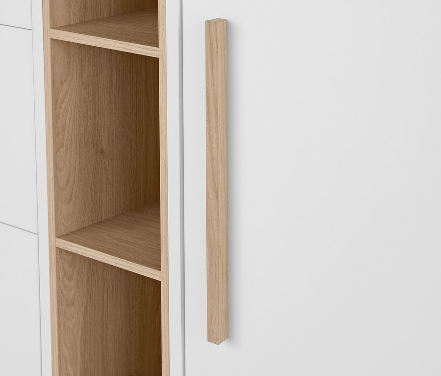 Detail einer weißen »Eklund« Kommode mit Schubladen und Tür, mit Holzgriff und offenen Regalen.