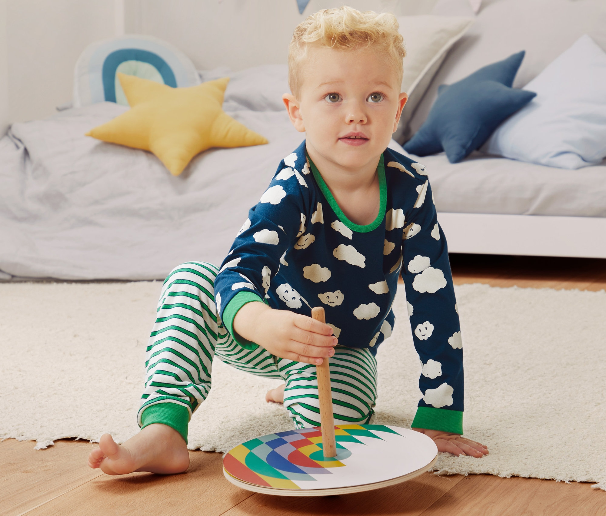 Junge spielt mit buntem Spielzeug auf dem Boden, trägt dabei einen 2er-Pack Pyjama aus Bio-Baumwolle.