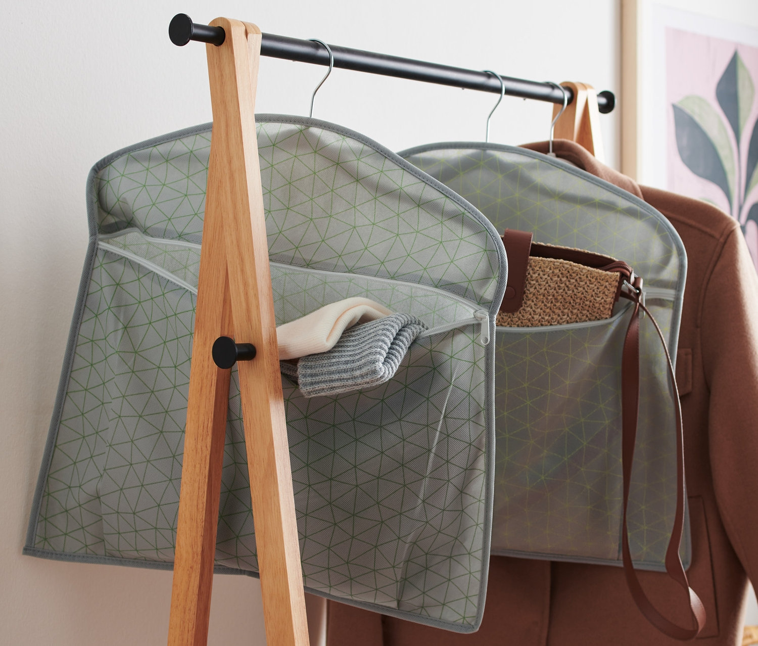 Zwei graue Schrankorganizer hängen an Kleiderbügeln an einer Kleiderstange.