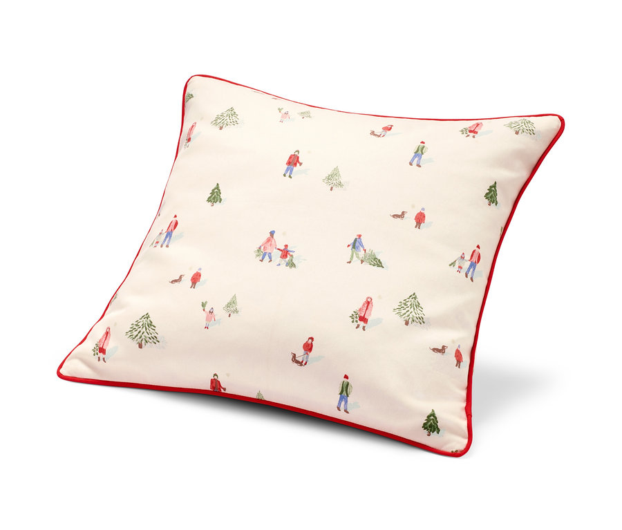 Ein Dekokissen-Bezug mit rotem Rand und Winterlandschaftsmuster.