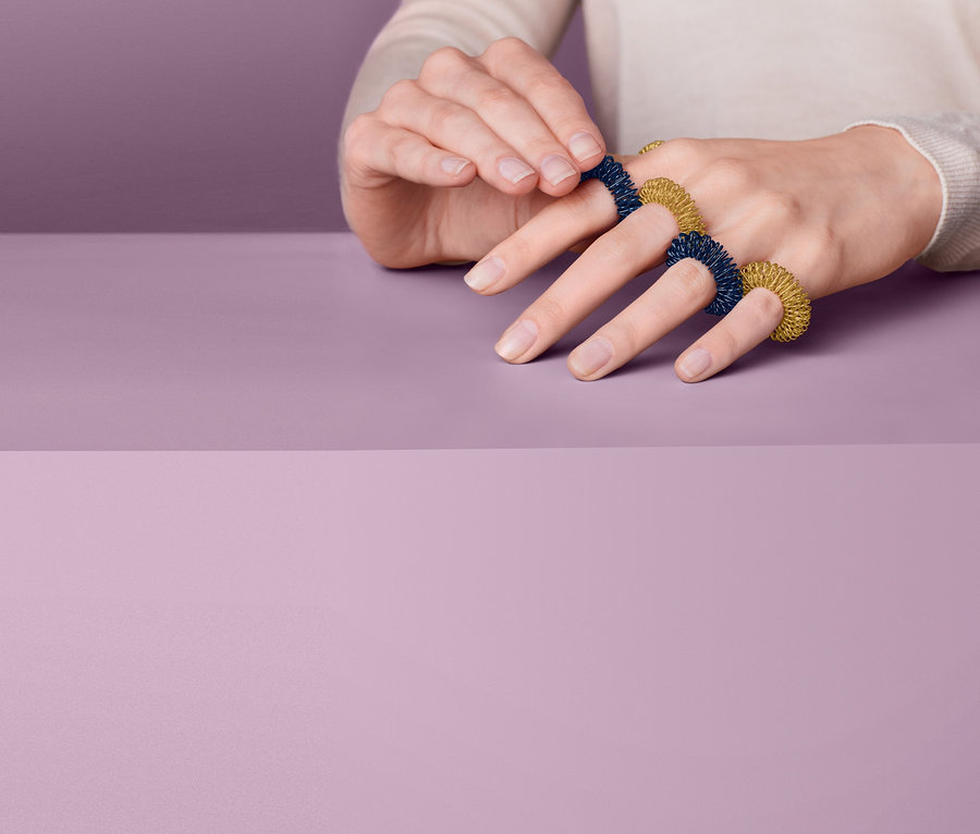 Frau legt Fingermassageringe an.