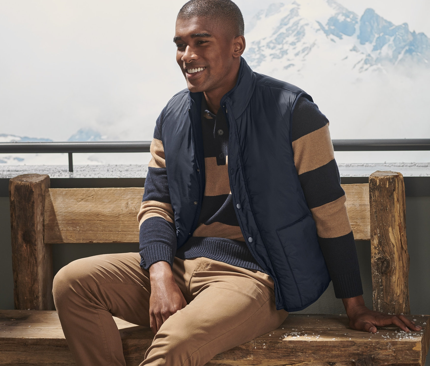 Mann sitzt auf einer Bank und trägt eine Wendeweste.