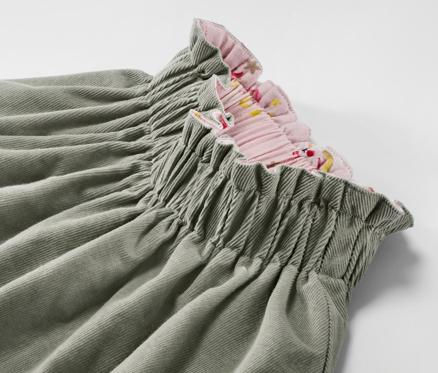 Detailaufnahme eines Kinder-Cord-Wende-Rocks mit Blumendetail am rosa Saum.