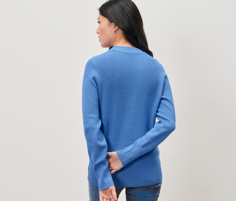 Frau von hinten trägt einen blauen Feinstrickpullover.