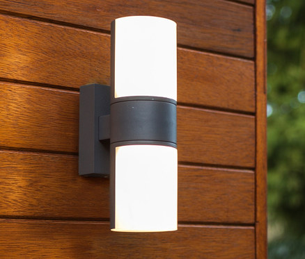 Eine Oudoor LED Wandleuchte ist an einer Holzwand befestigt.