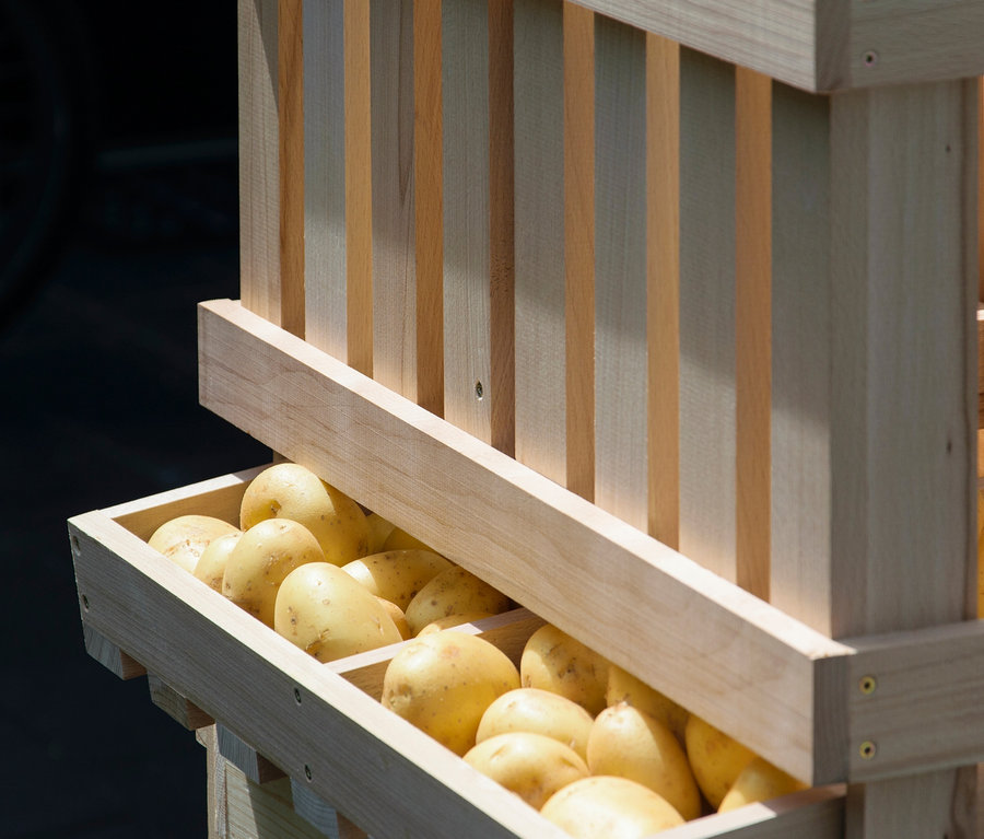 Gelbe Kartoffeln in einem Vorratsbehälter aus Holz.