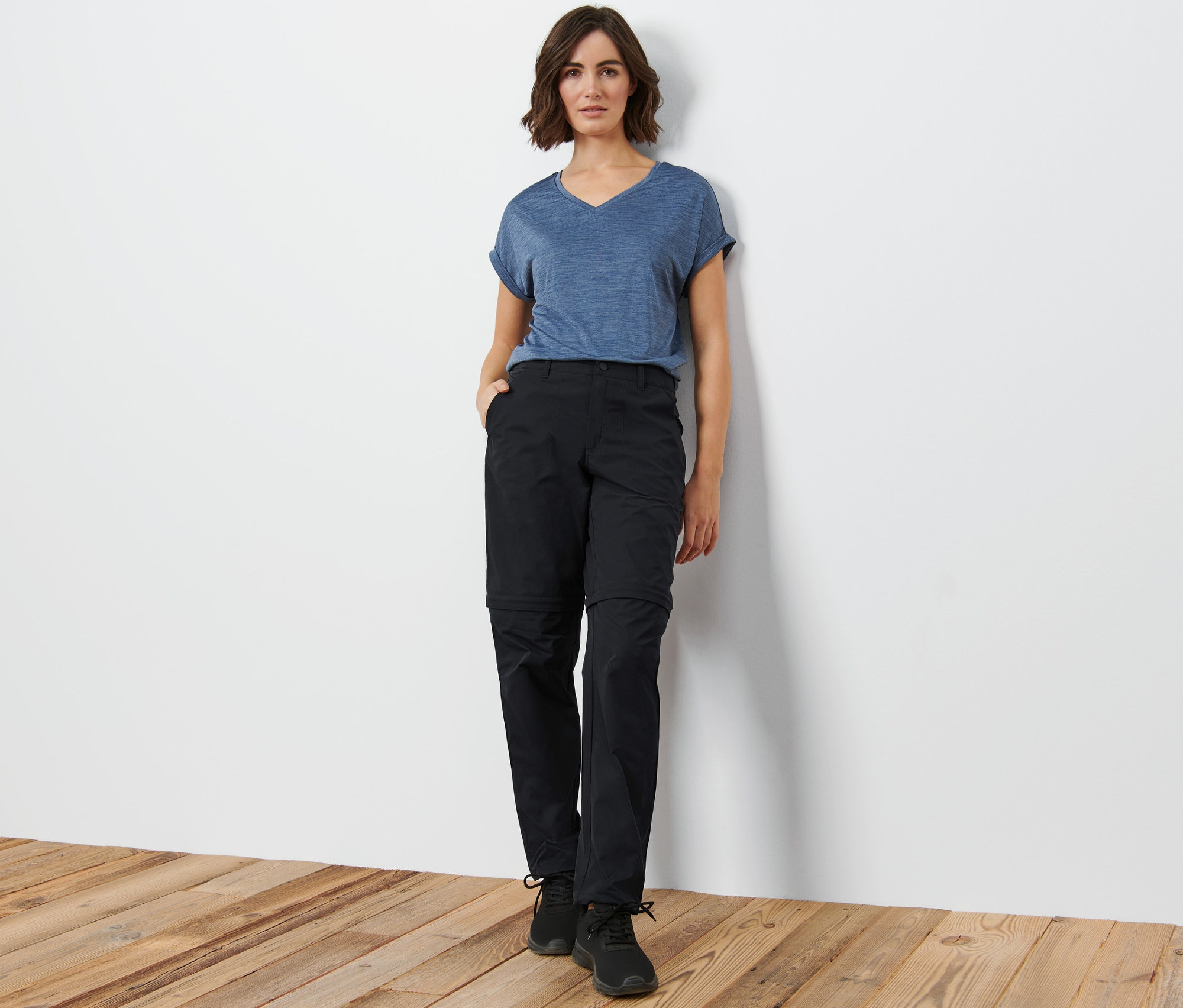 Frau posiert in schwarzer 2-in-1-Funktionshose.