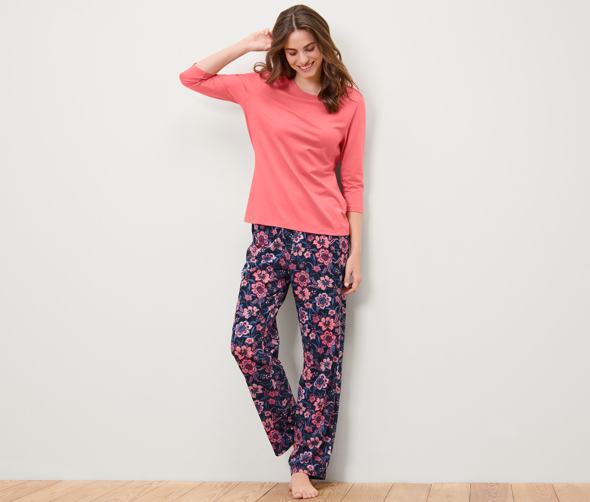 Frau posiert in einem Pyjama mit Blumenmuster.