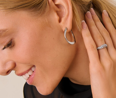 Blonde Frau trägt Creolen Wave und 925 Silber Ring Wave.