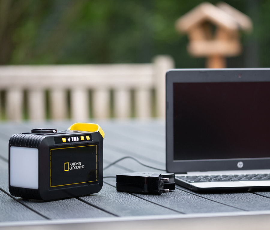 Eine schwarze und gelbe National Geographic Mobile Power Station ist mit einem Laptop und einem schwarzen Adapter verbunden.