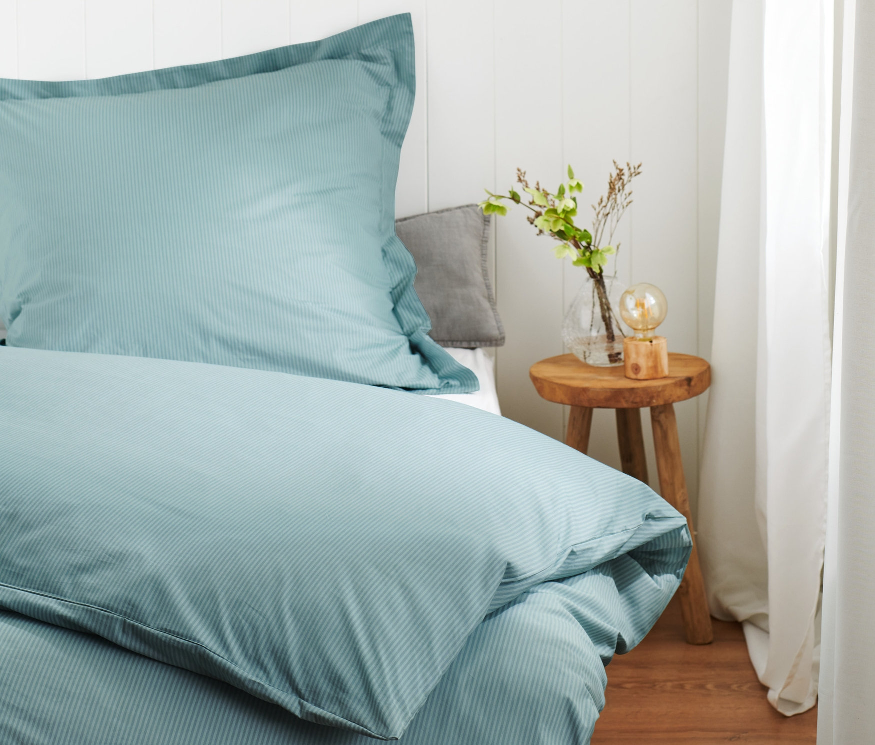 Hellblaue Premium-Baumwoll-Bettwäsche in Normalgröße auf einem Bett.