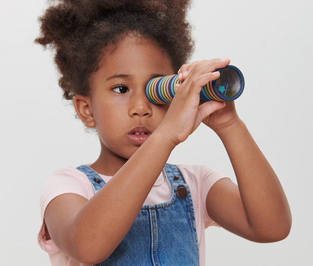 Mädchen schaut durch Kaleidoskop.