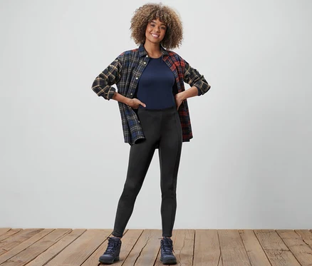 Frau posiert in Thermotights, T-Shirt und Flanellhemd.