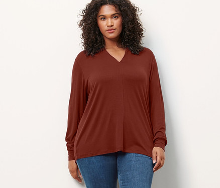 Eine Frau steht und trägt ein Blusenshirt mit V-Ausschnitt und Treggings »Fit Nelly«.