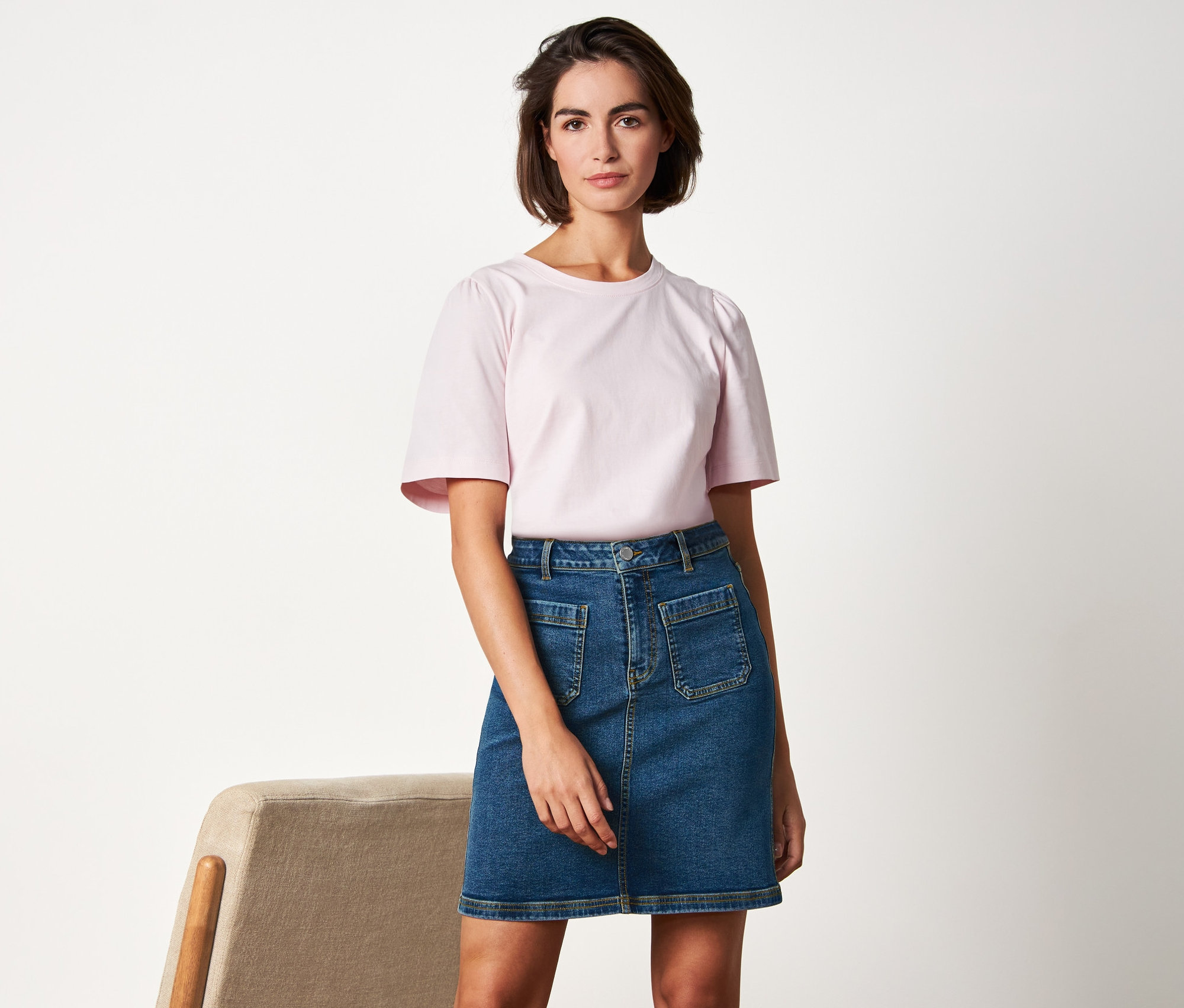 Frau posiert in Jeansrock.