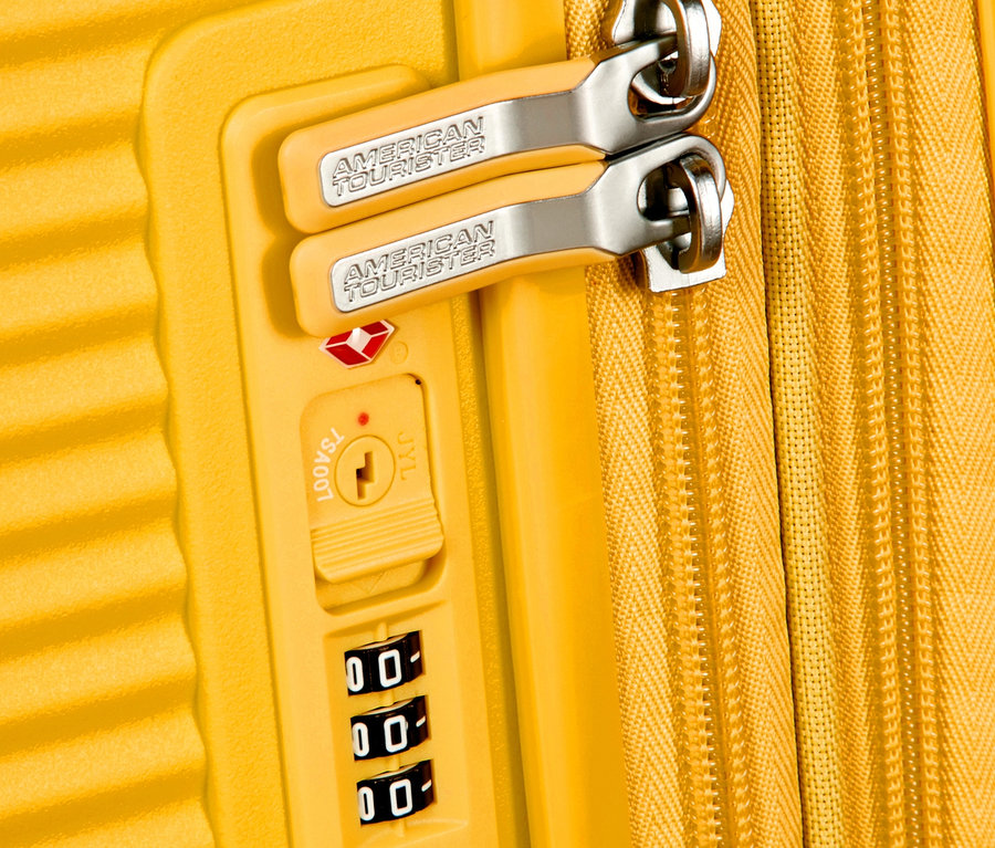 Detailansicht eines golden yellowfarbenen American Tourister Hartschalen-Koffers »Soundbox« mit Reißverschluss und Zahlenschloss.