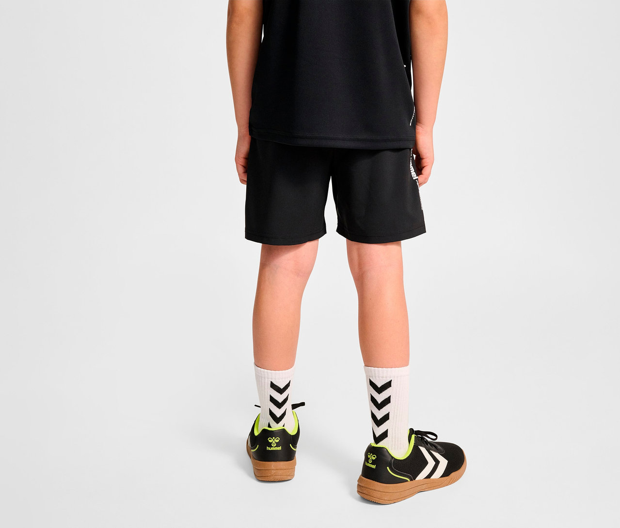 Junge von hinten, trägt schwarze Hummel HMLJR Pulse Workout Shorts.