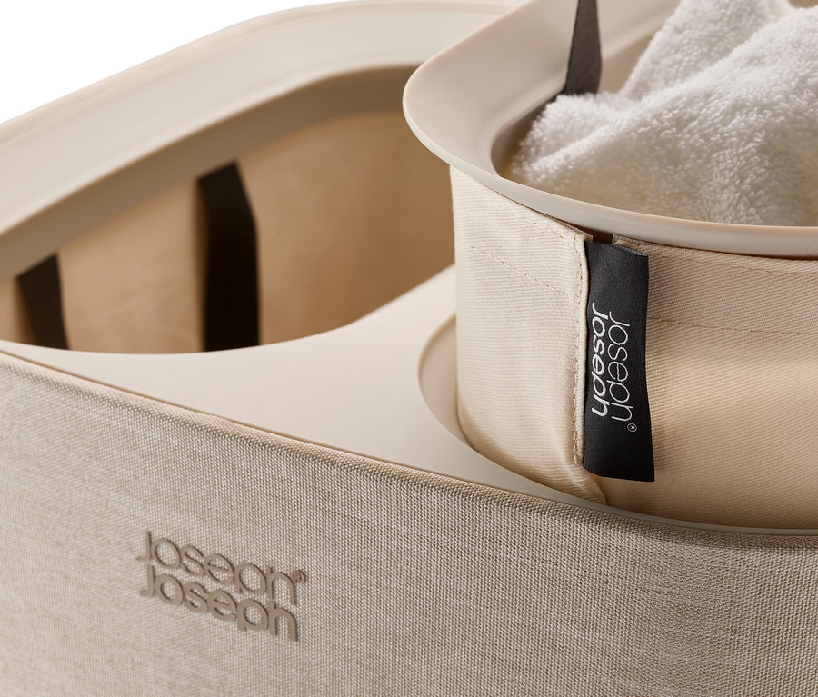 Detailaufnahme eines beigen Joseph Joseph Wäschekorbs mit weißem Handtuch.