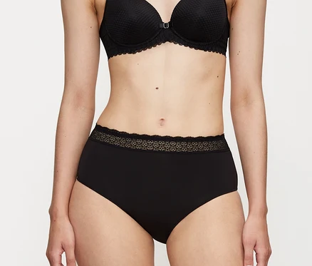 Person trägt schwarze Triumph Feel of Modal Midi Slips mit Spitzenbesatz am Bund und einen schwarzen BH.