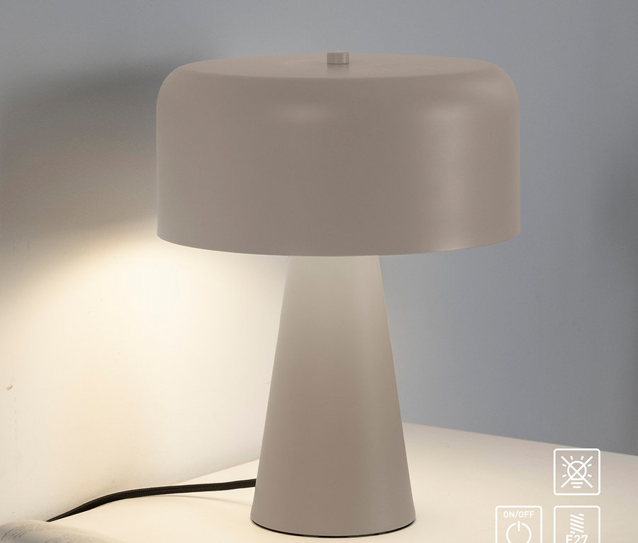 Weiße Tischlampe leuchtet auf einem weißen Nachttisch neben einem offenen Buch.