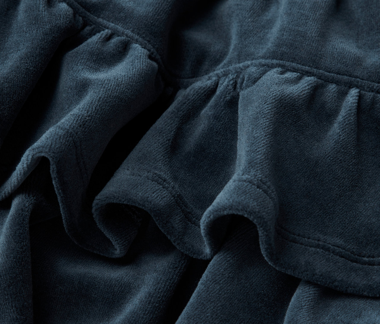 Detailaufnahme eines blauen Stoffes mit Falten.